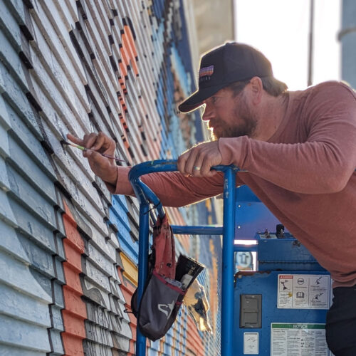 Artist Scott Takes, owner of Underground Art Studios, painting the mural at Sacred Cow Tavern in Cedar Rapids, Iowa.